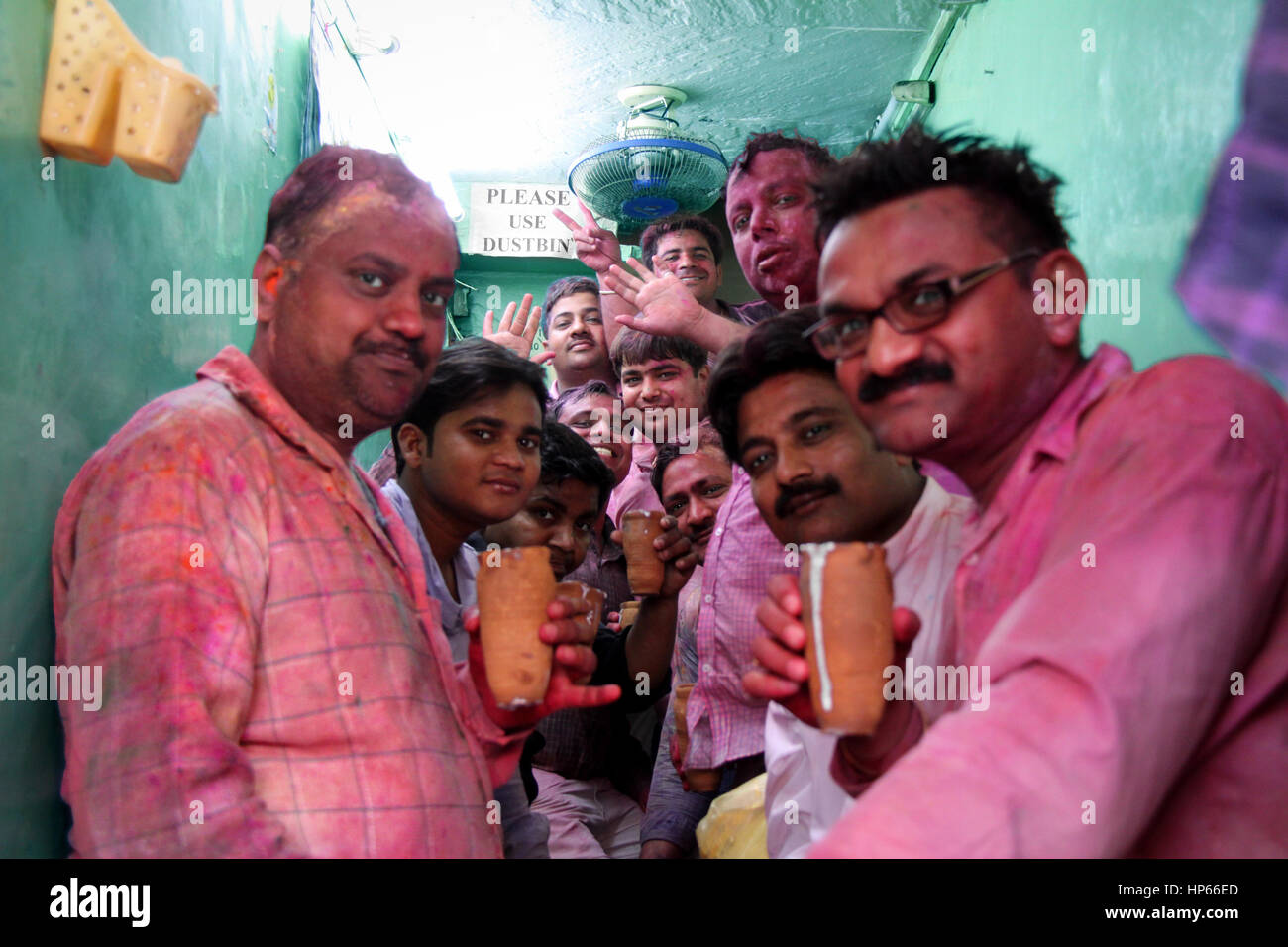 Gruppe von Männern mit Holi Farben trinken Lassi während Holi feiern in Vrindavan, Indien abgedeckt Stockfoto