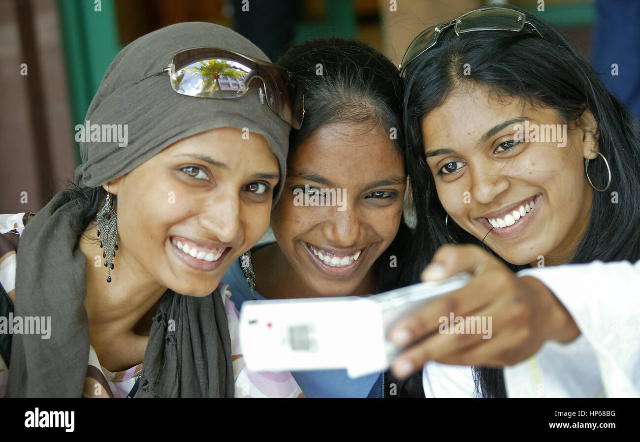 Caudan Waterfront im Hafen der Hauptstadt Port Louis, junge Frauen, die das Fotografieren mit ihrer Zelle Telefon, Mauritius, Caudan Waterfront, junge Frauen, die eine Stockfoto