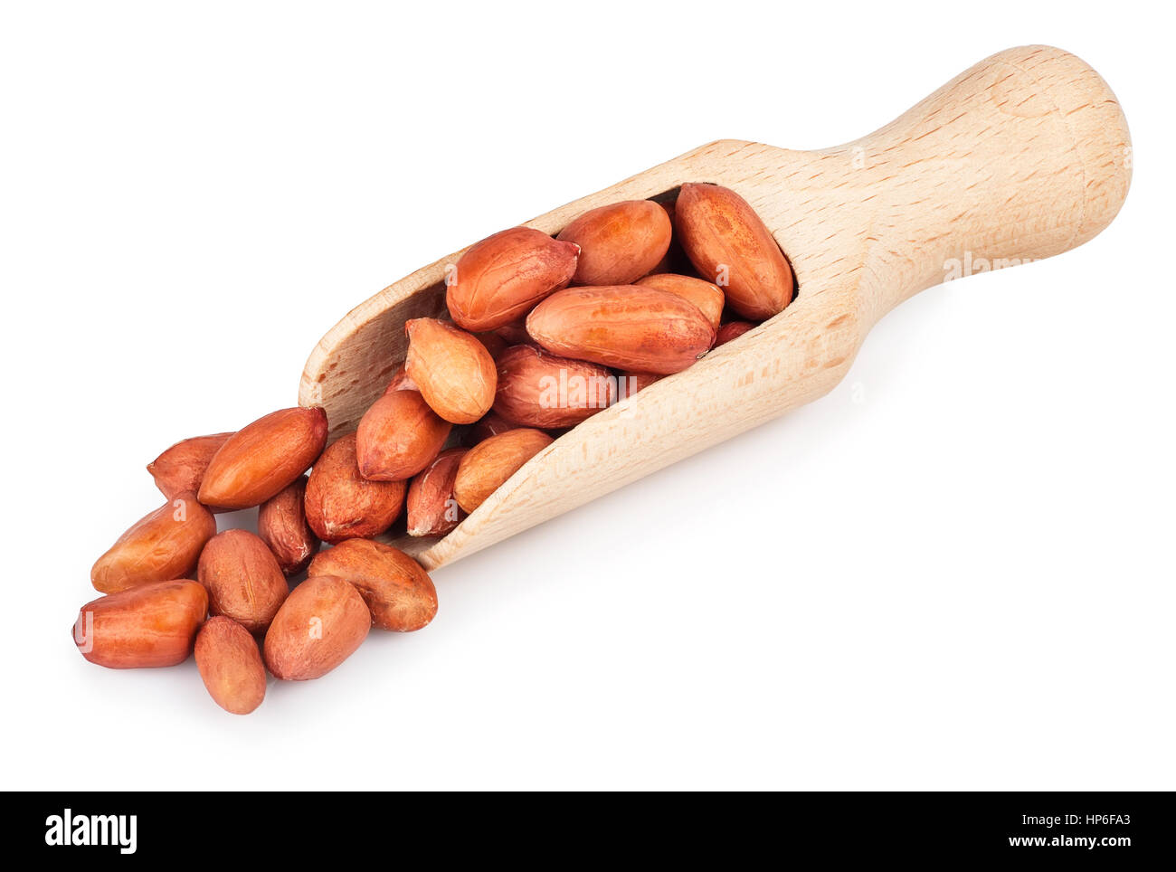 Erdnuss in hölzerne Schaufel isoliert auf weißem Hintergrund. Rohe Erdnüsse in Kochlöffel auf weißem Hintergrund Stockfoto