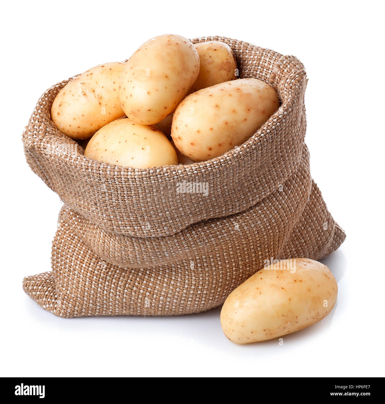 neue frische rohe Kartoffeln in Tasche isoliert auf weißem Hintergrund. Reife Kartoffeln im Leinensack isoliert auf weißem Hintergrund Stockfoto