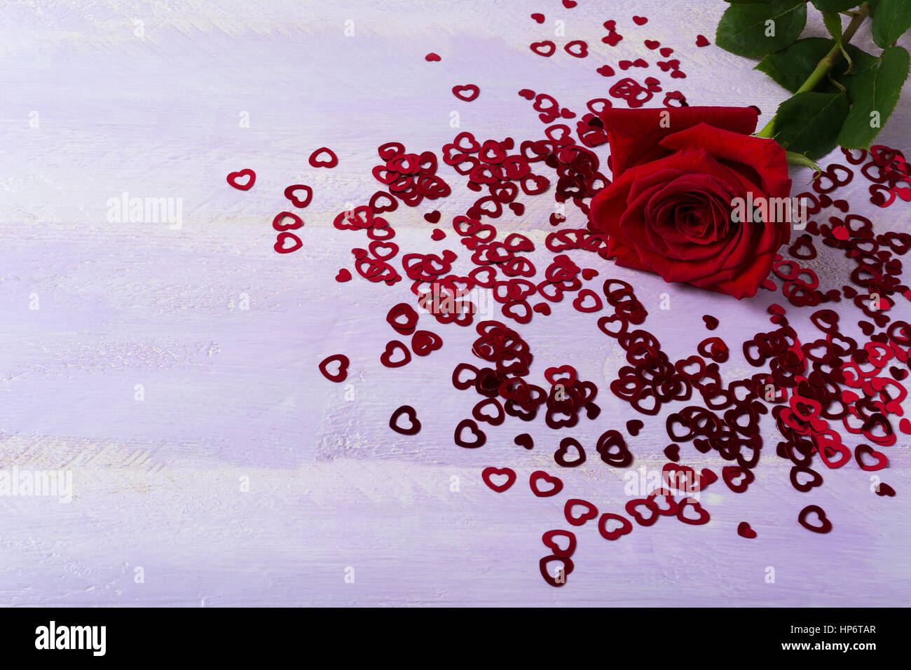 Burgunder Rose und St. Valentine Day Symbole auf lila Hintergrund. Elegante Hochzeitseinladung oder Grußkarte. Kopieren Sie Raum. Stockfoto