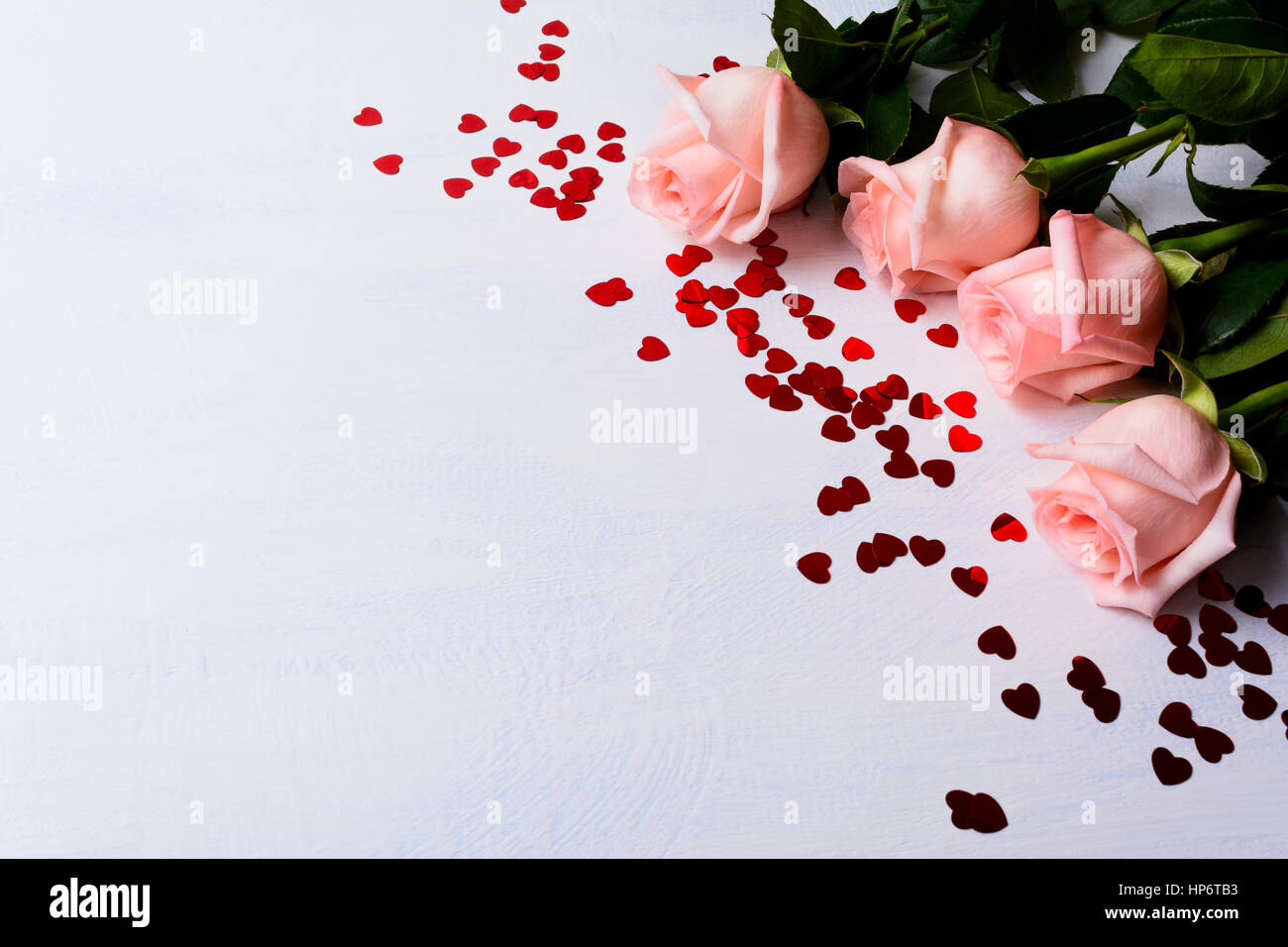 Hochzeit-Hintergrund mit blass rosa Rosen und roten Herzen. Elegant-Valentinstag Grußkarte mit Blumen- und Urlaub-Symbol. Kopieren Sie Raum. Stockfoto