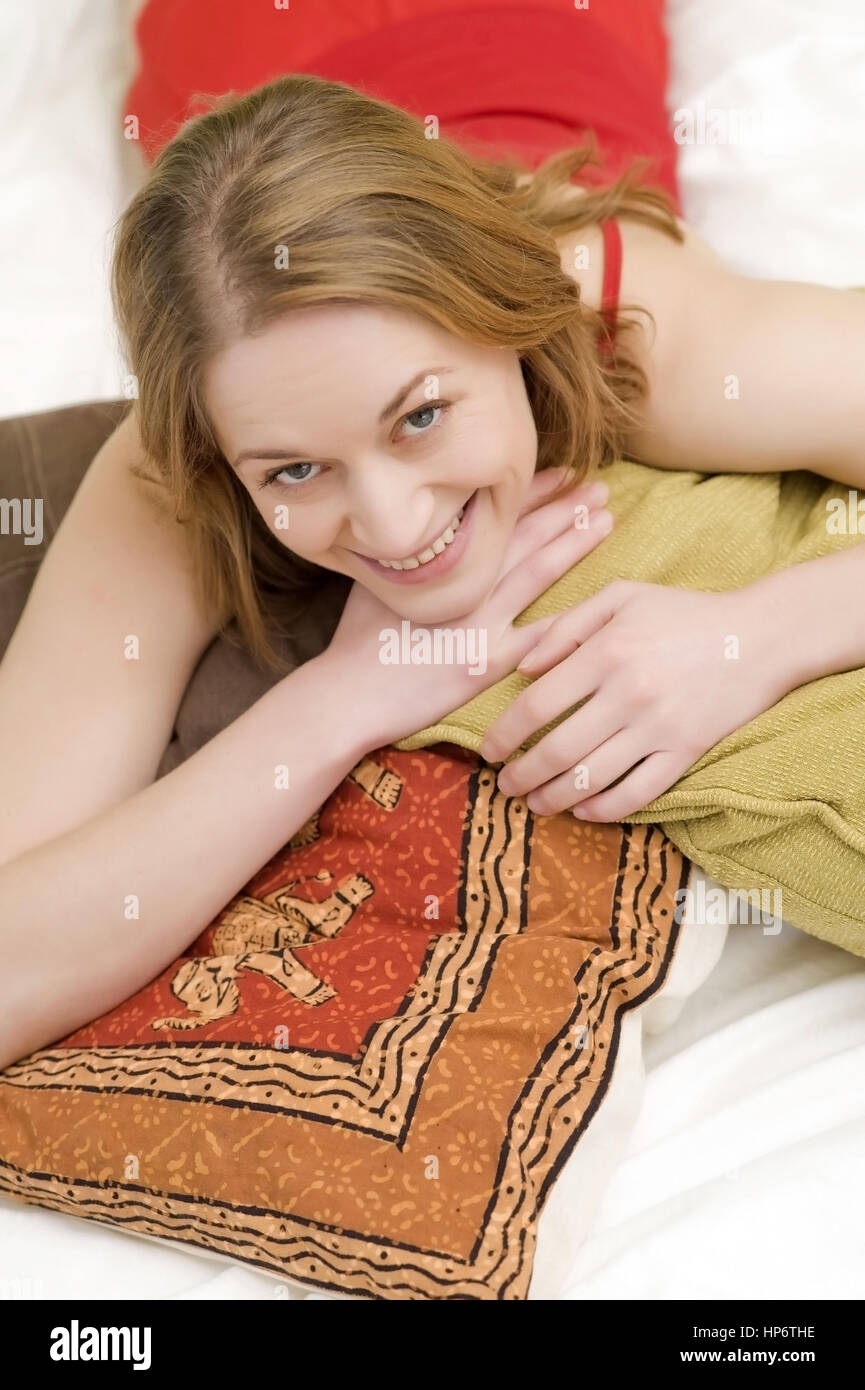 Model Release, Junge Frau, 25 +, so Mit Kissen Auf Dem Bett - Frau mit Kissen auf dem Bett liegend Stockfoto