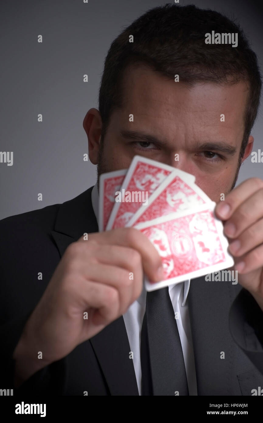 Model Release, Mann Mit Pokerface Beim Kartenspiel - Mann Spielkarten Stockfoto