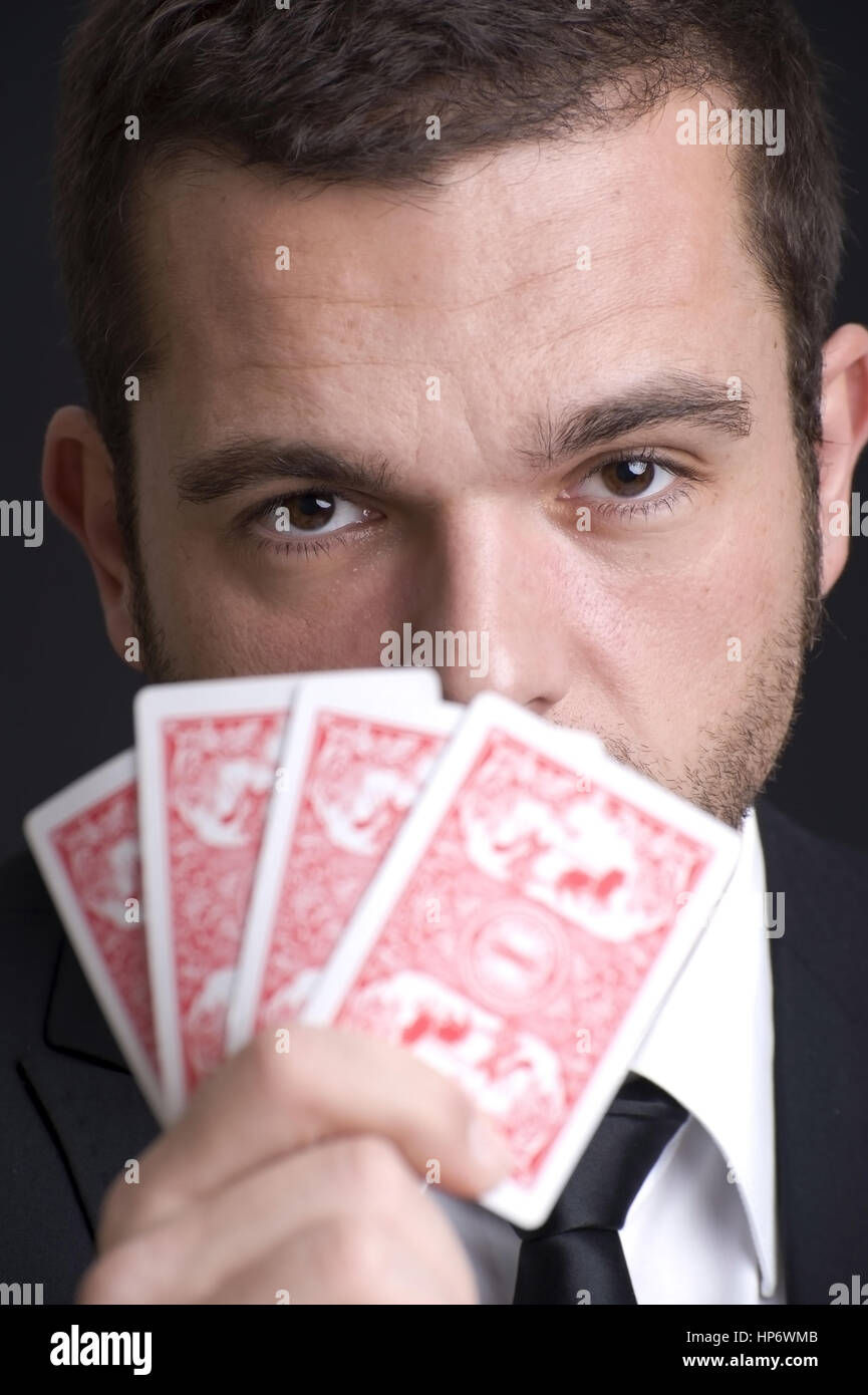Model Release, Mann Mit Pokerface Beim Kartenspiel - Mann Spielkarten Stockfoto