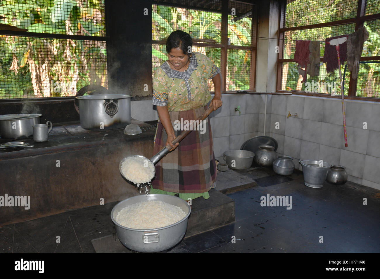 Mumbai, Indien - 28. Oktober 2015 - Frau Kochen Reis in einer traditionellen Küche in Indien am offenen Feuer Stockfoto