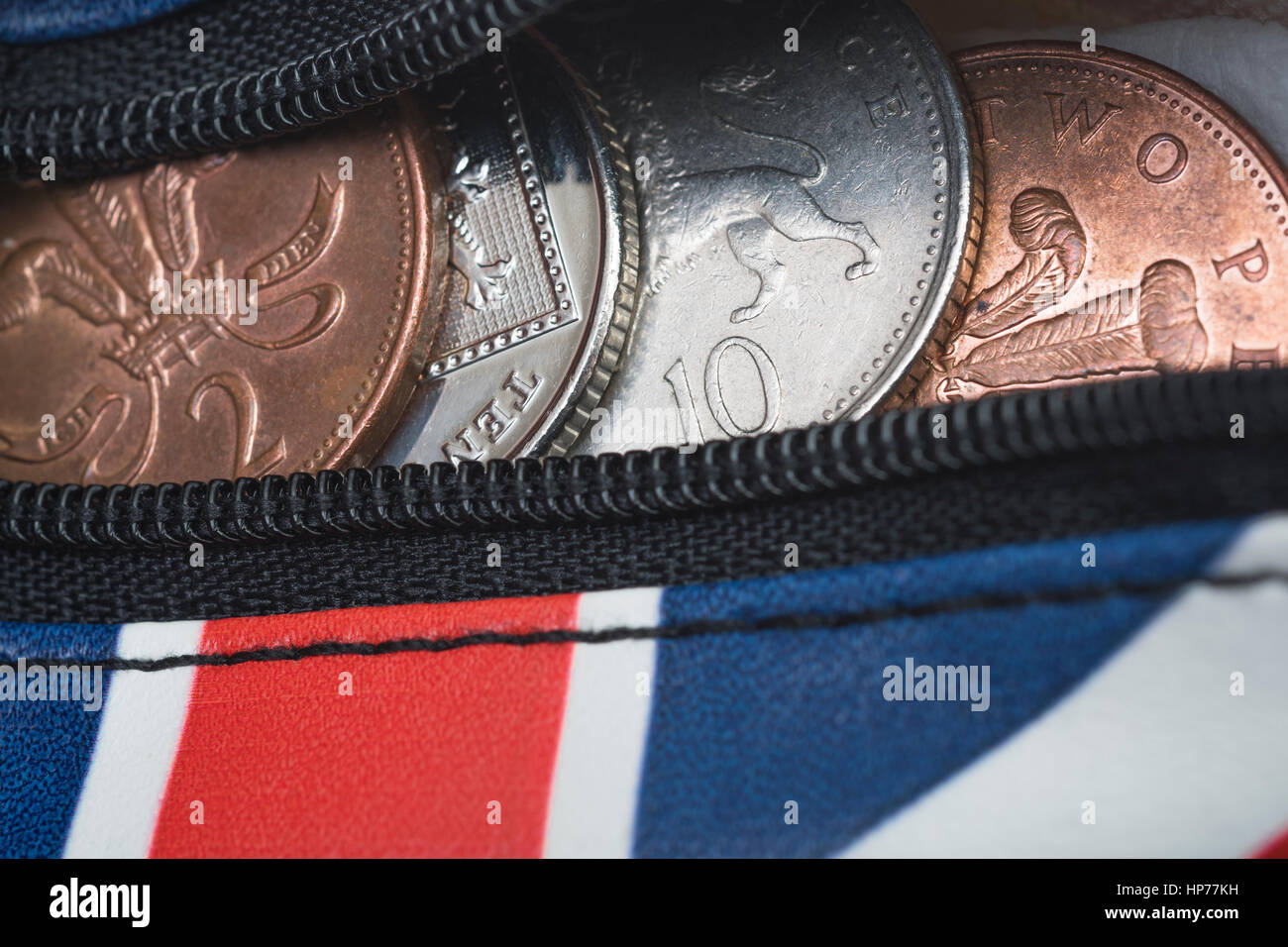 Mit Reißverschluss Union Jack Geldbeutel mit britischen Münzen / Münzen sichtbar. Metapher für Pennies, die Ausgaben der privaten Haushalte, die Budgets, steigende Preise. Stockfoto