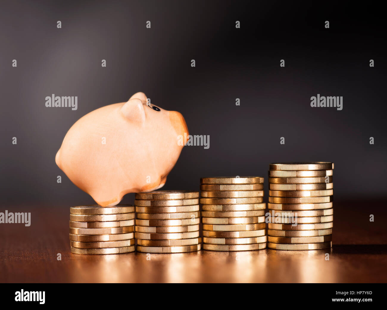 Piggy Bank stehend auf Haufen von Münzen. Stockfoto