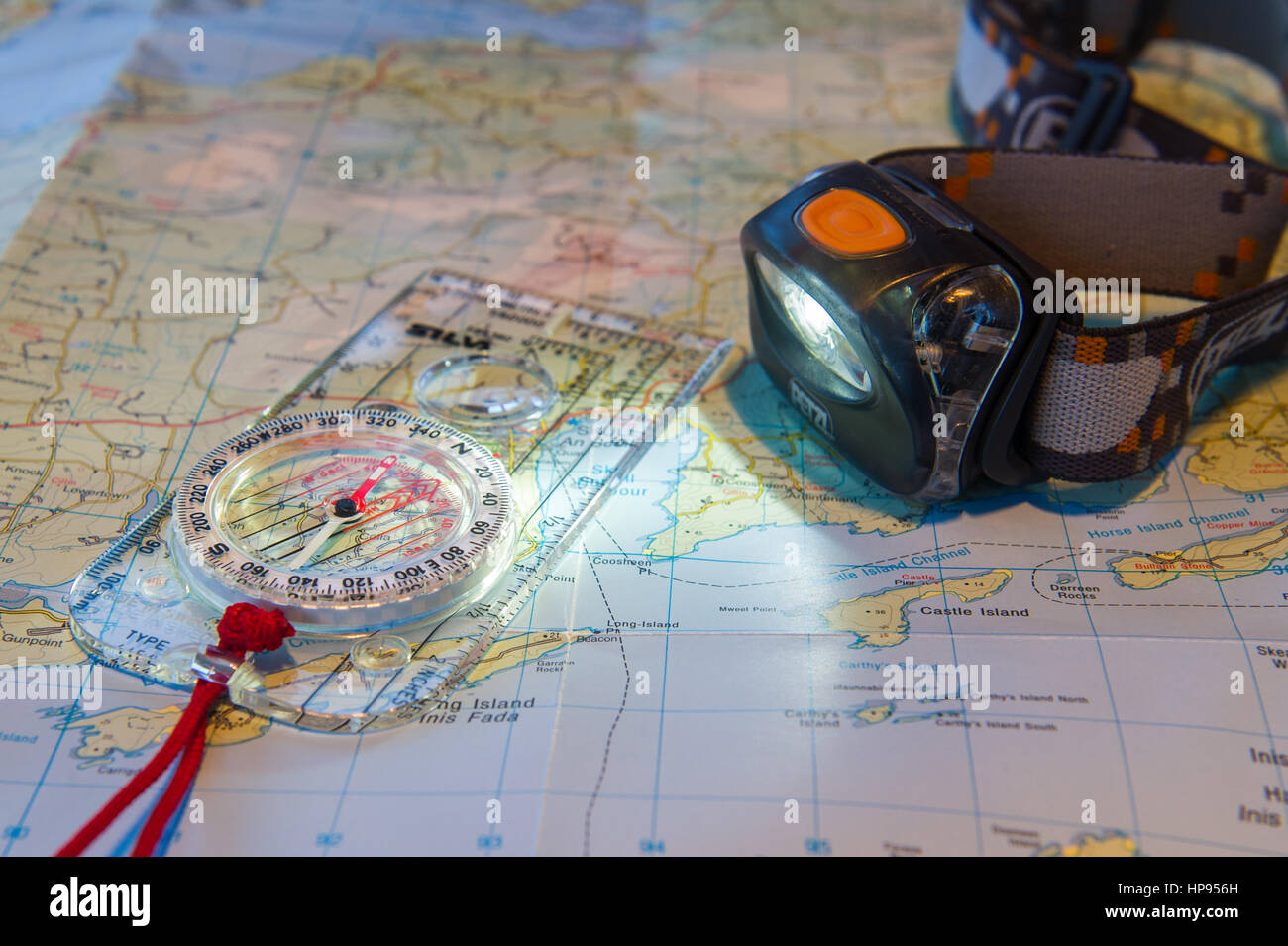Petzl Headtorch und Silva Kompass auf einer Karte von Irland. Stockfoto