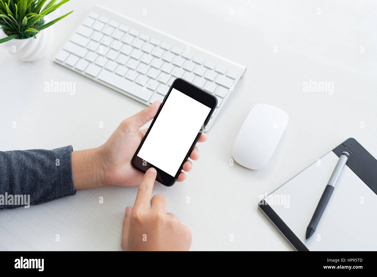 Hand halten Telefon Mobil und Workspace-Tabelle zu berühren Stockfoto
