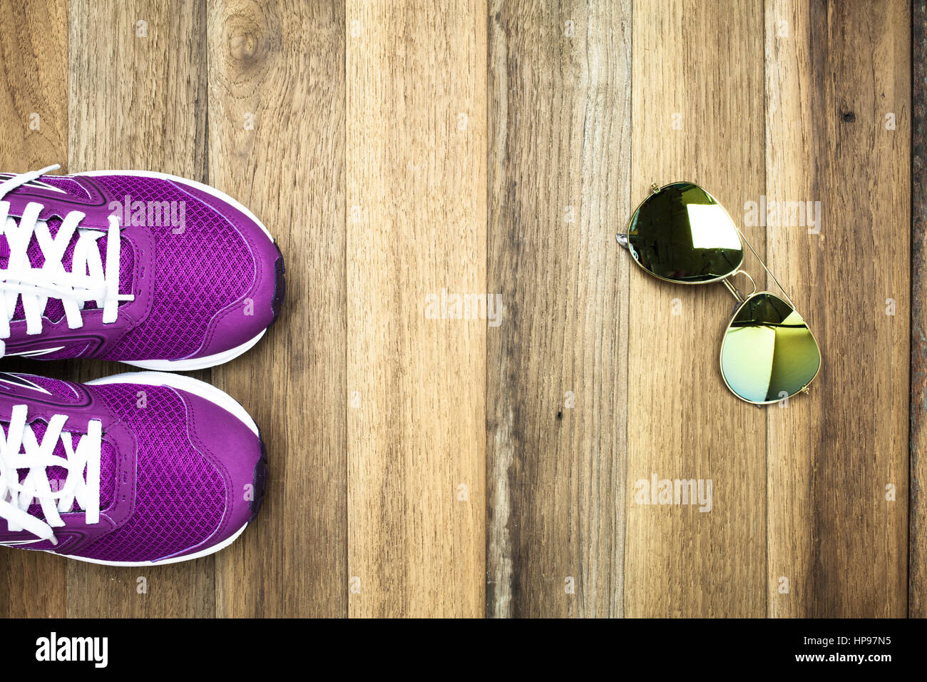 Lila Sneaker und Sonnenbrille auf hölzernen Hintergrund Stockfoto