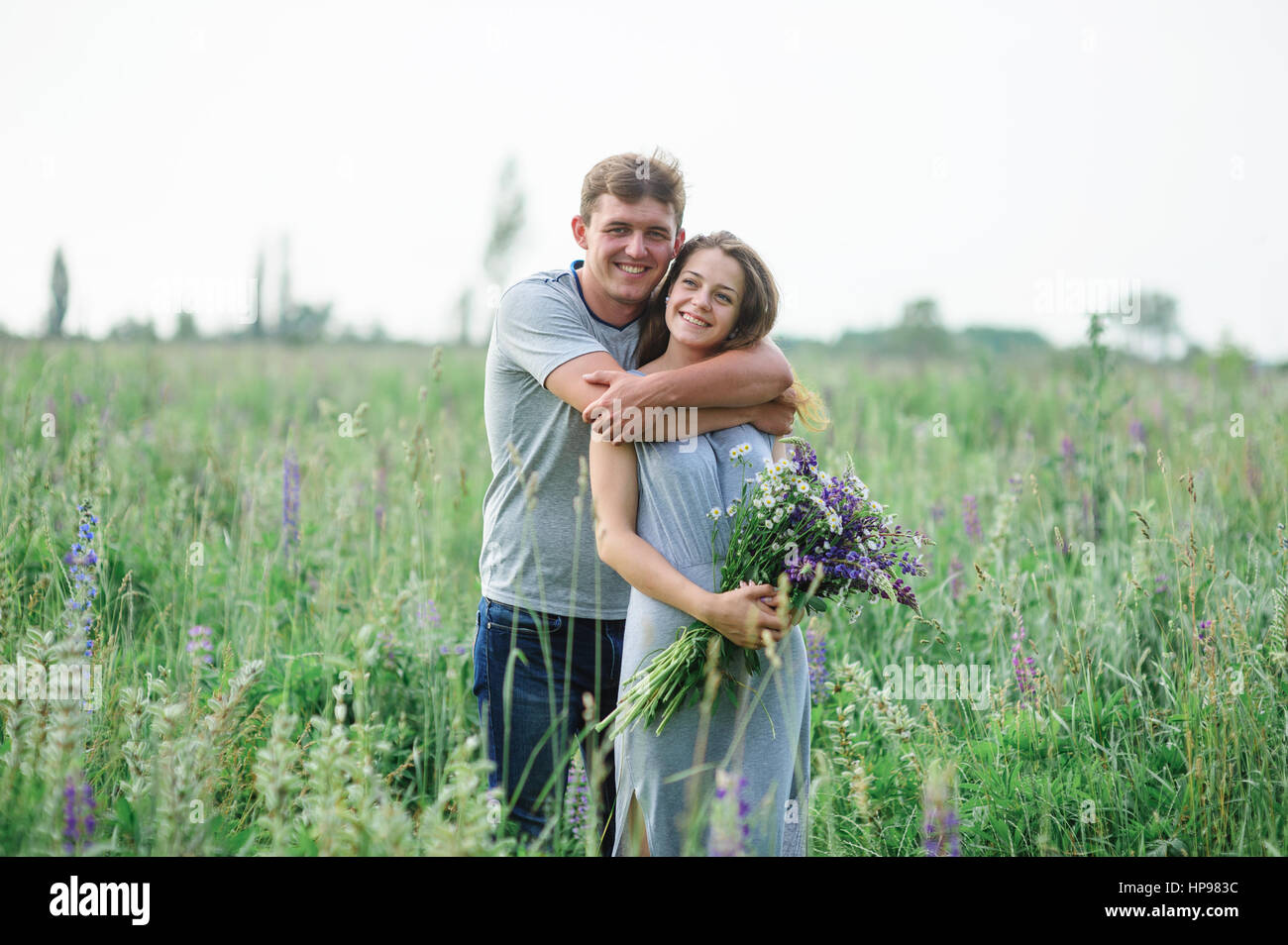 junges Paar umarmt auf Sommerwiese Stockfoto