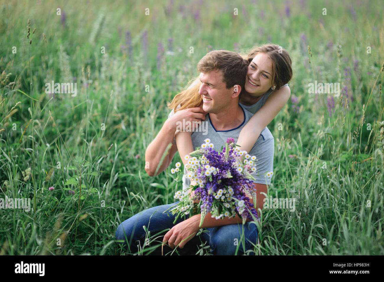 junges Paar umarmt auf Sommerwiese Stockfoto