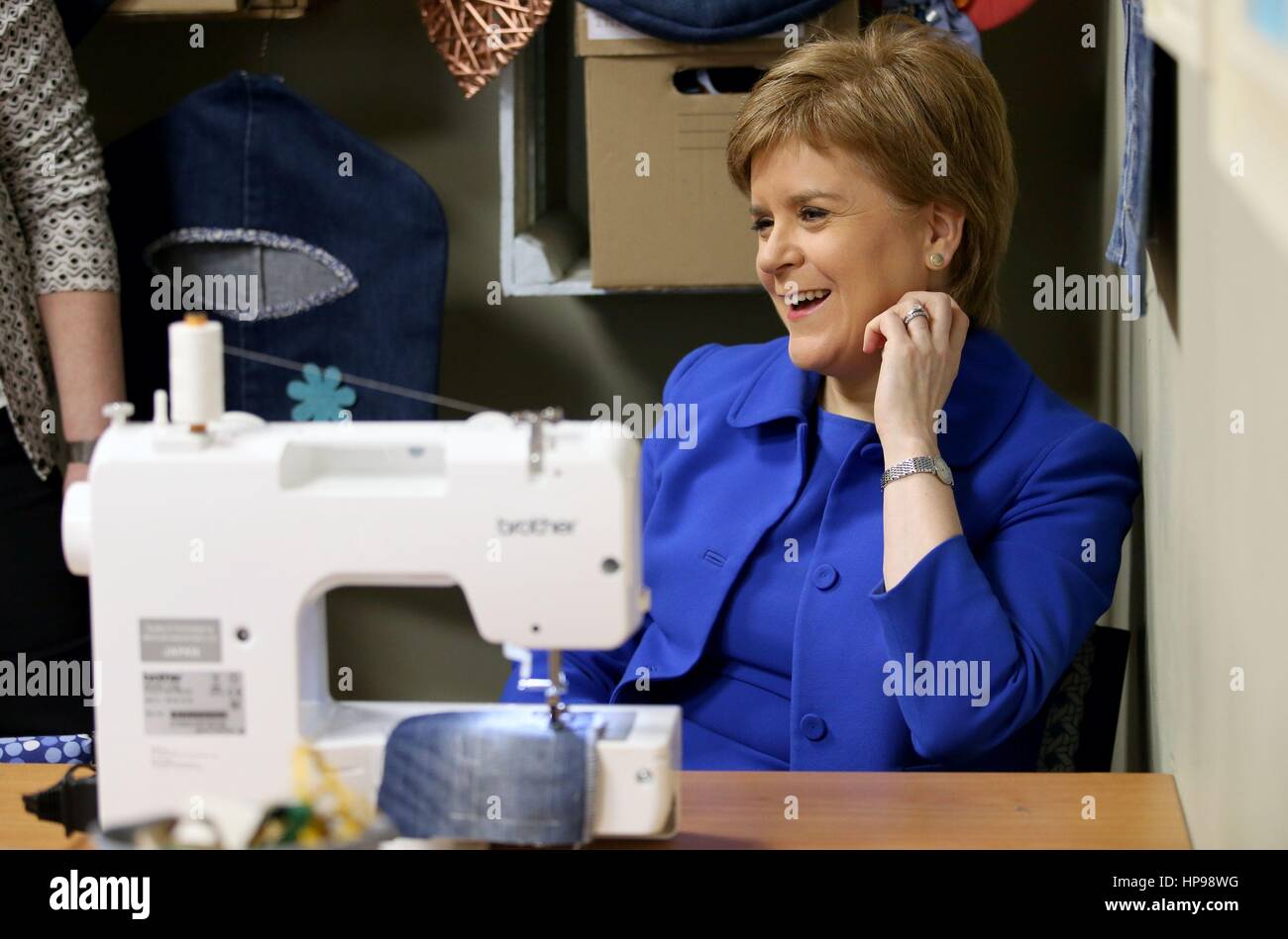 Erste Minister Nicola Sturgeon beteiligt sich an einer Jeans recycling Werkstatt während eines Besuchs in R: Kleidung, ein Upcycling-Gemeindezentrum in Rutherglen, bevor er eine Ankündigung auf den Klimafonds Herausforderung zu entwickeln. Stockfoto