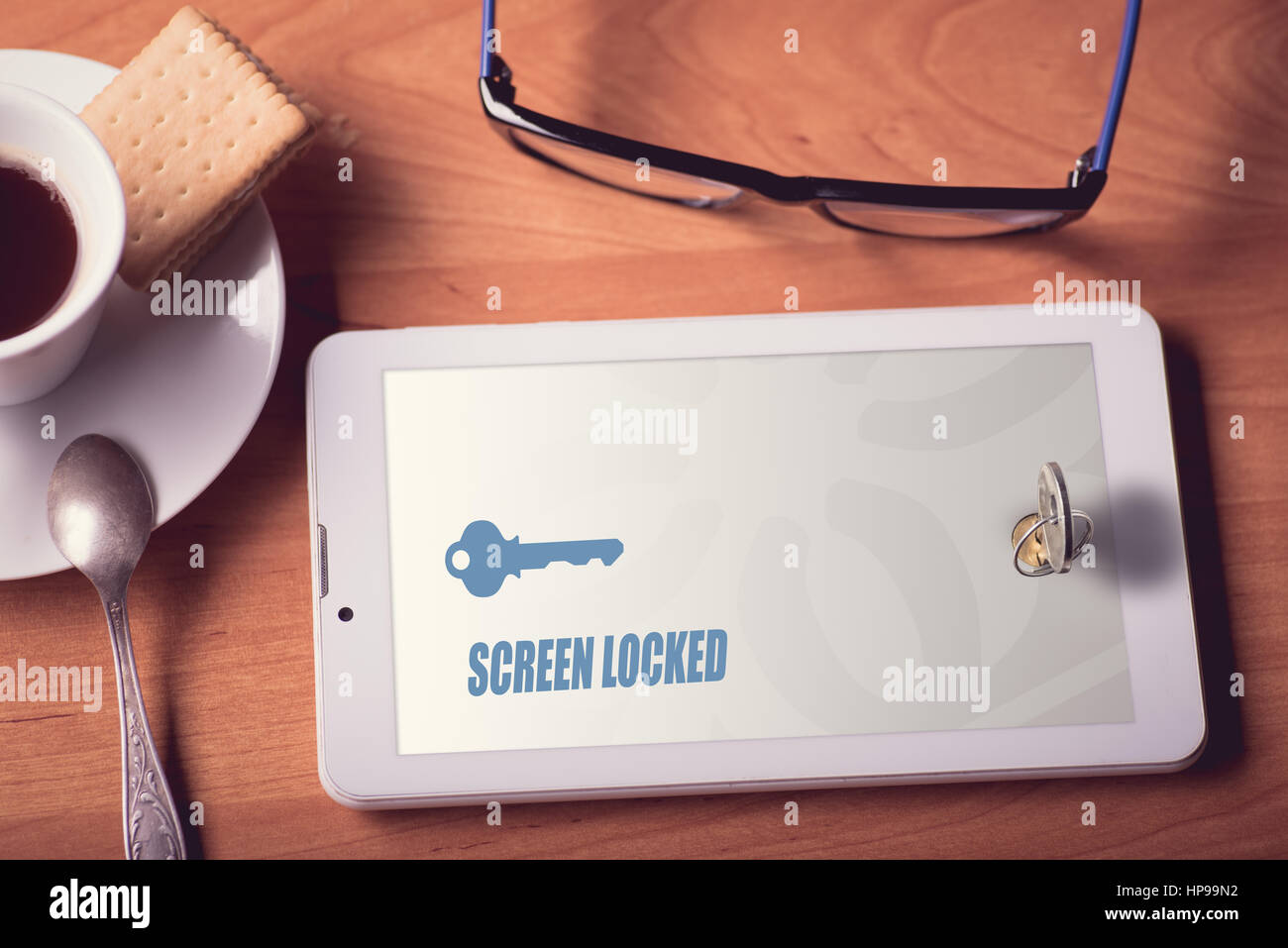 Tablet-Bildschirm mit dem echten Schloss mit Schlüssel gesperrt Stockfoto