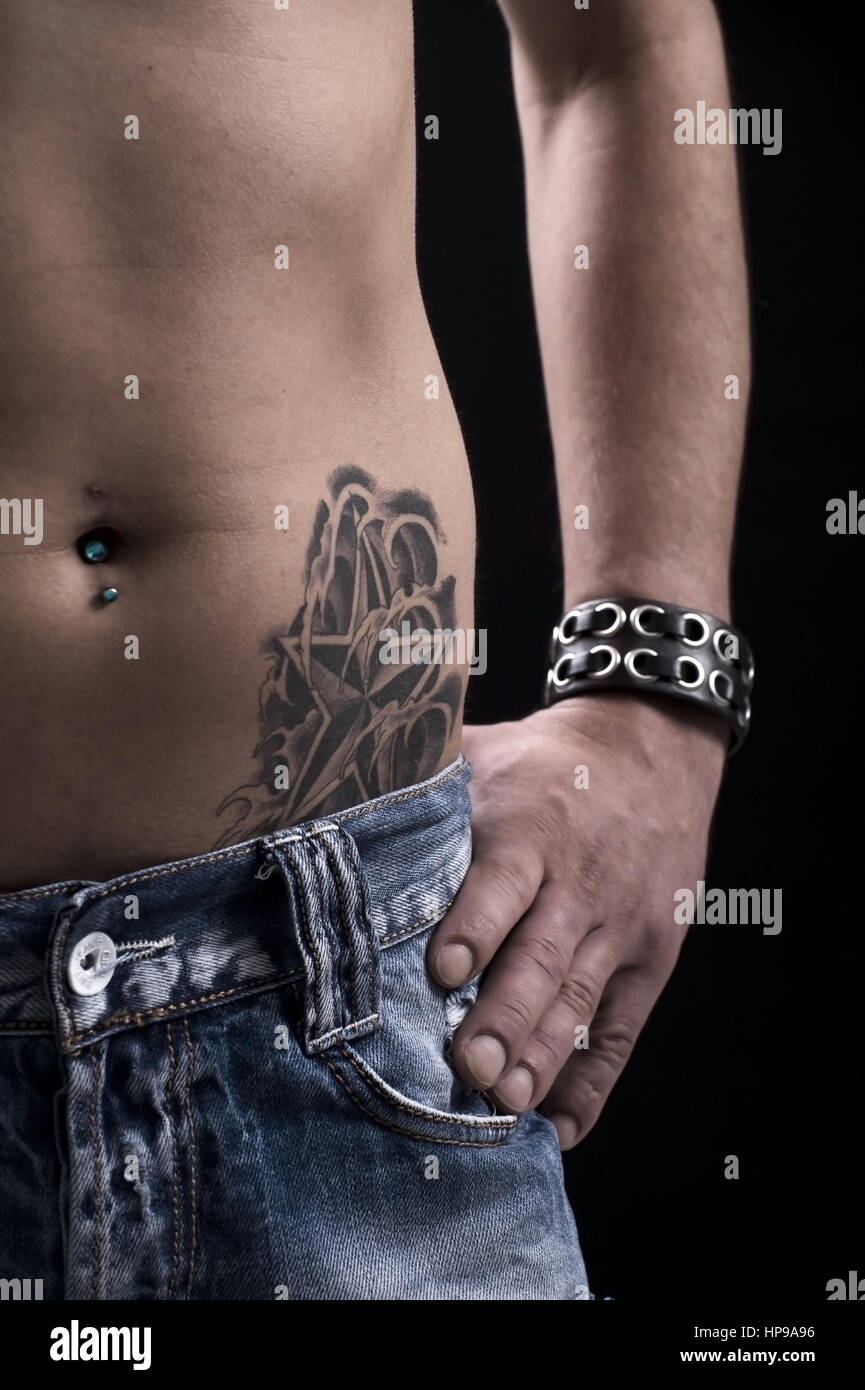 Modell veröffentlicht, Junger, t? Towierter Mann Mit Bauchnabelpiercing -  junger Mann mit Tattoo und piercing Stockfotografie - Alamy
