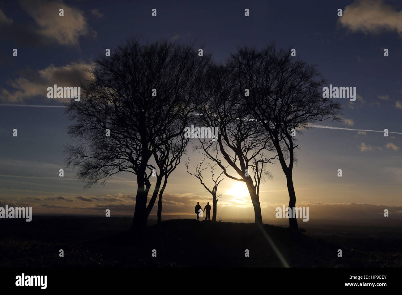 Die Sonne geht hinter den Seven Sisters runden Grabhügel, Copt Hill, Houghton-le-Feder, wie ungewöhnlich warmen Wetter ergreift in ganz Großbritannien. Stockfoto