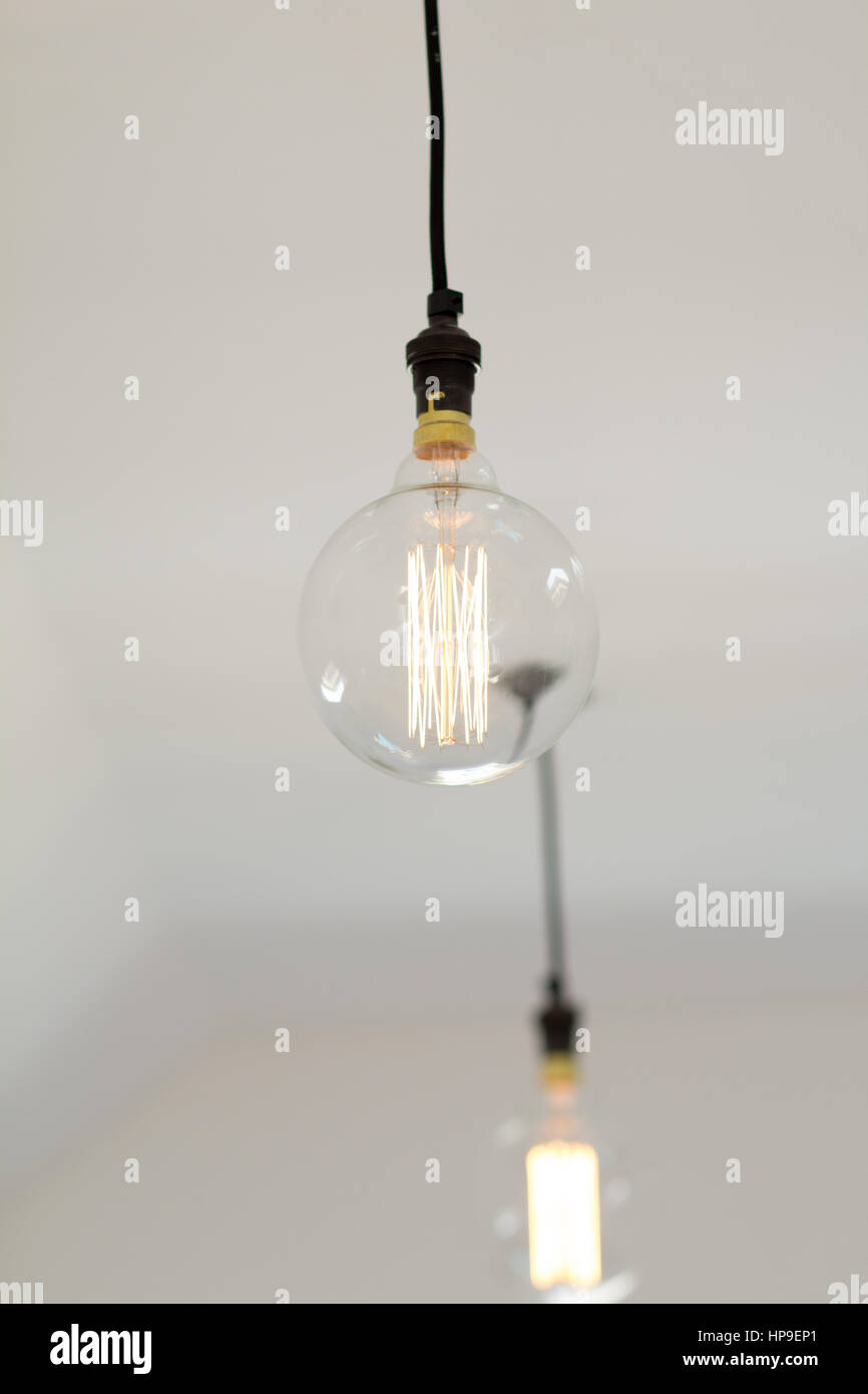 Ein modernes Edison style LED Glühbirne hängt von einer weissen Decke Stockfoto