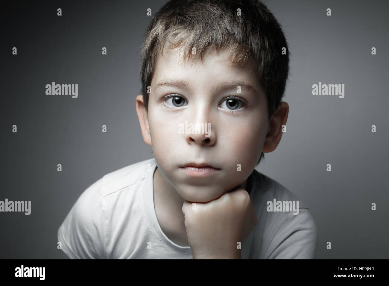 Porträt von ein hübscher Junge Cam suchen. Auf den grauen Hintergrund isoliert Stockfoto