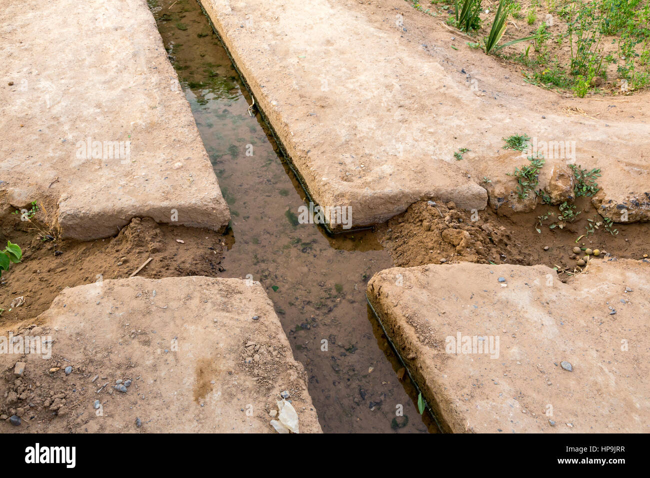 Merzouga, Marokko.  Bewässerung-Kanal führt das Wasser auf landwirtschaftlichen Flächen in der Oase Merzouga.  Zwei Punkte der Diversion sind gesperrt, so dass Wasser fließt, Stockfoto