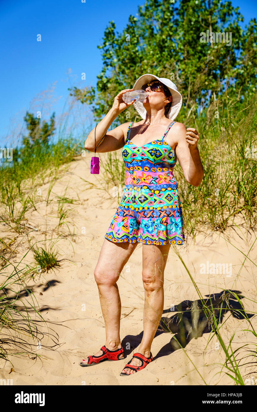 Frau ist Trinkwasser beim Wandern in den Dünen in Nord-Michigan Stockfoto