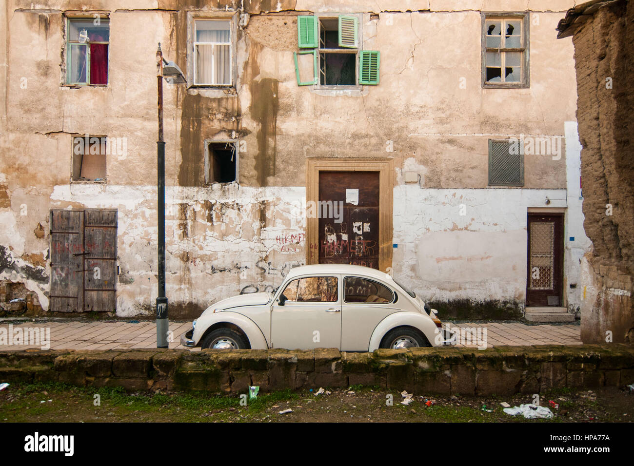 Ein altes Auto parkte vor verlassenen Häusern neben der Wand, die die Stadt Nikosia, Zypern zu trennen. Nikosia der südlichen gliederte sich in griechisch-zyprischen und der türkisch-zyprischen Nordteilen 1963, nach der interkommunalen Gewalt, die in der Stadt ausbrach. Heute der nördliche Teil der Stadt ist die Hauptstadt von Nord-Zypern, ein de-facto-Staat, der als sein besetzt zyprischen Territoriums durch die internationale Gemeinschaft. © Simone Padovani / Erwachen Stockfoto