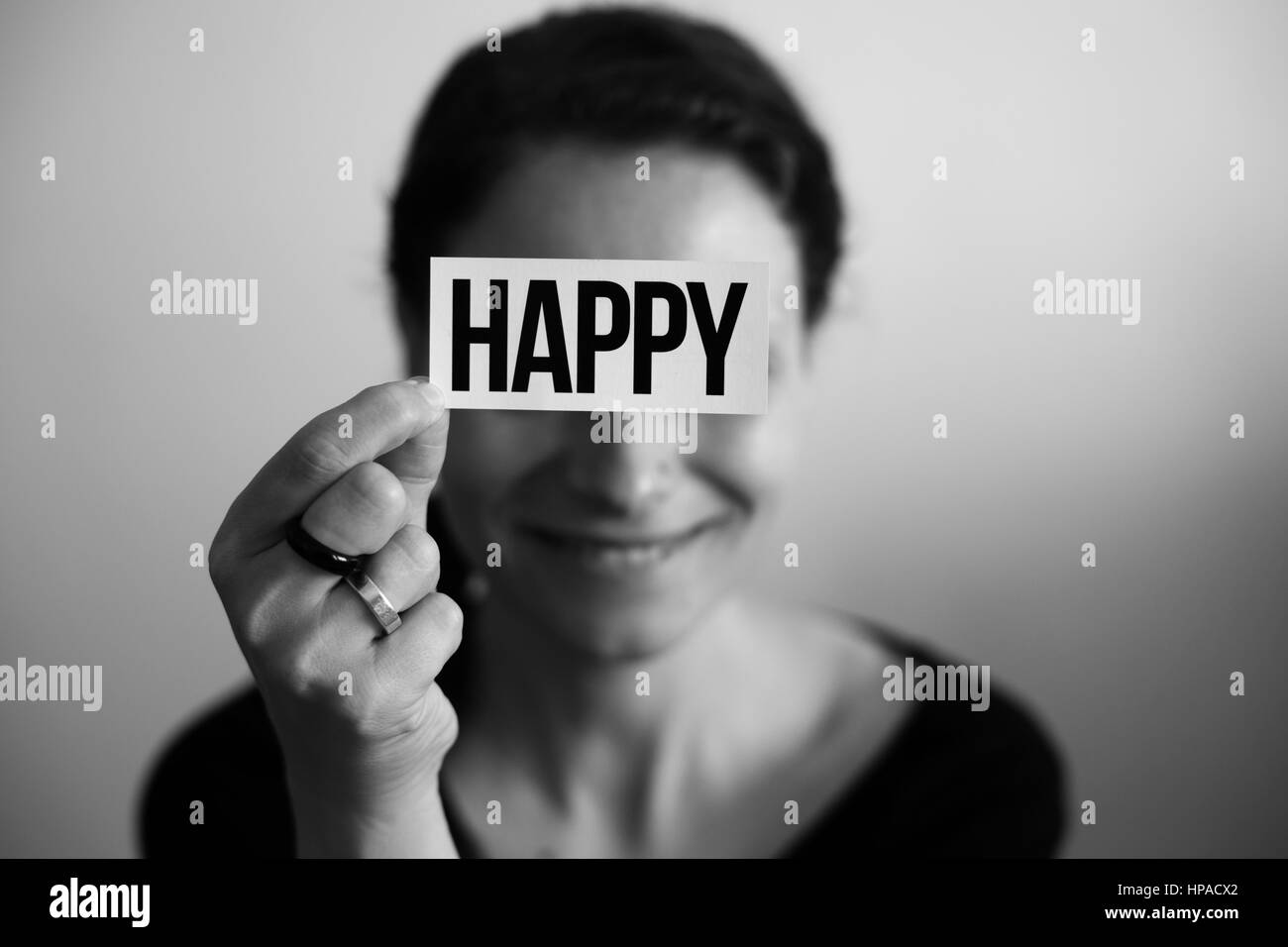 Porträt einer lachenden Frau hielt eine Karte mit Aufschrift Happy Stockfoto