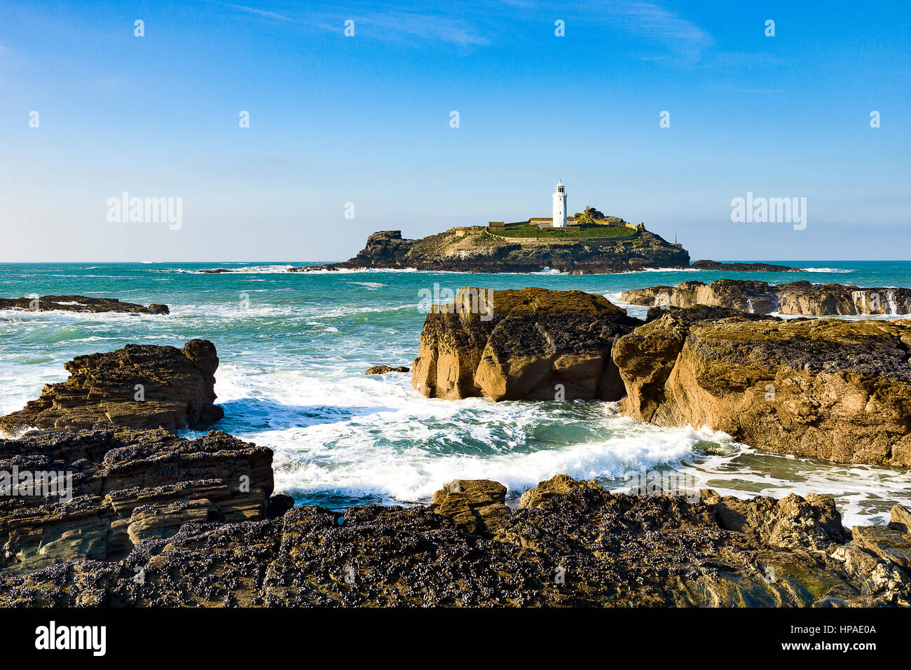 Godrevy Leuchtturm bei Ebbe an einem sonnigen Wintertag, machen große Wellen und blauem Himmel für einige dramatische Szenen Stockfoto