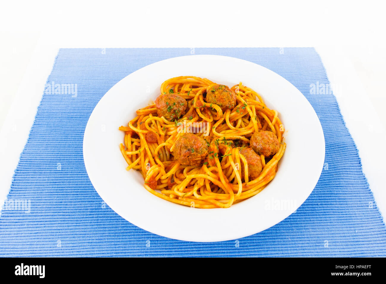 Hausgemachte pikante Sphagetti und Frikadellen, weißen Teller auf einer blauen Platzdeckchen. Stockfoto