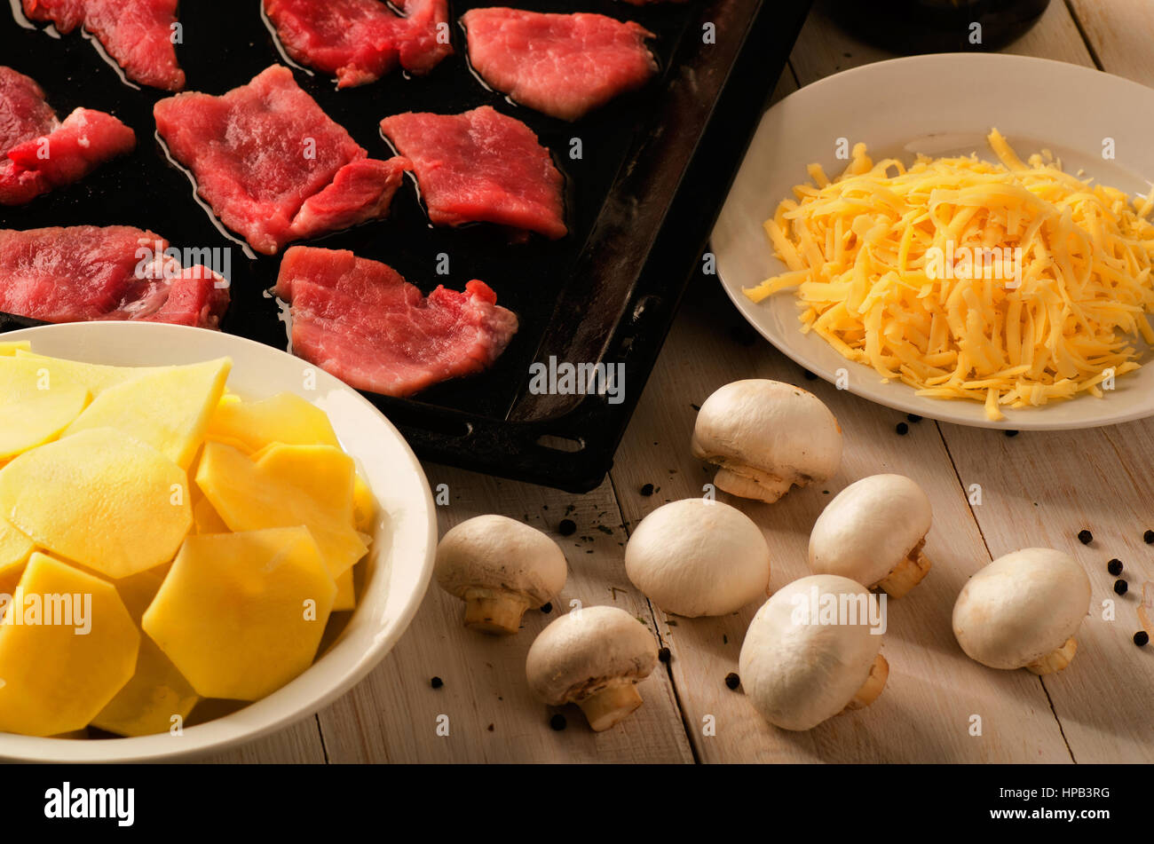Marmorierte Rindfleischsteak in der Pfanne mit Kartoffeln, Käse und Pilzen. Vorbereitung Stockfoto