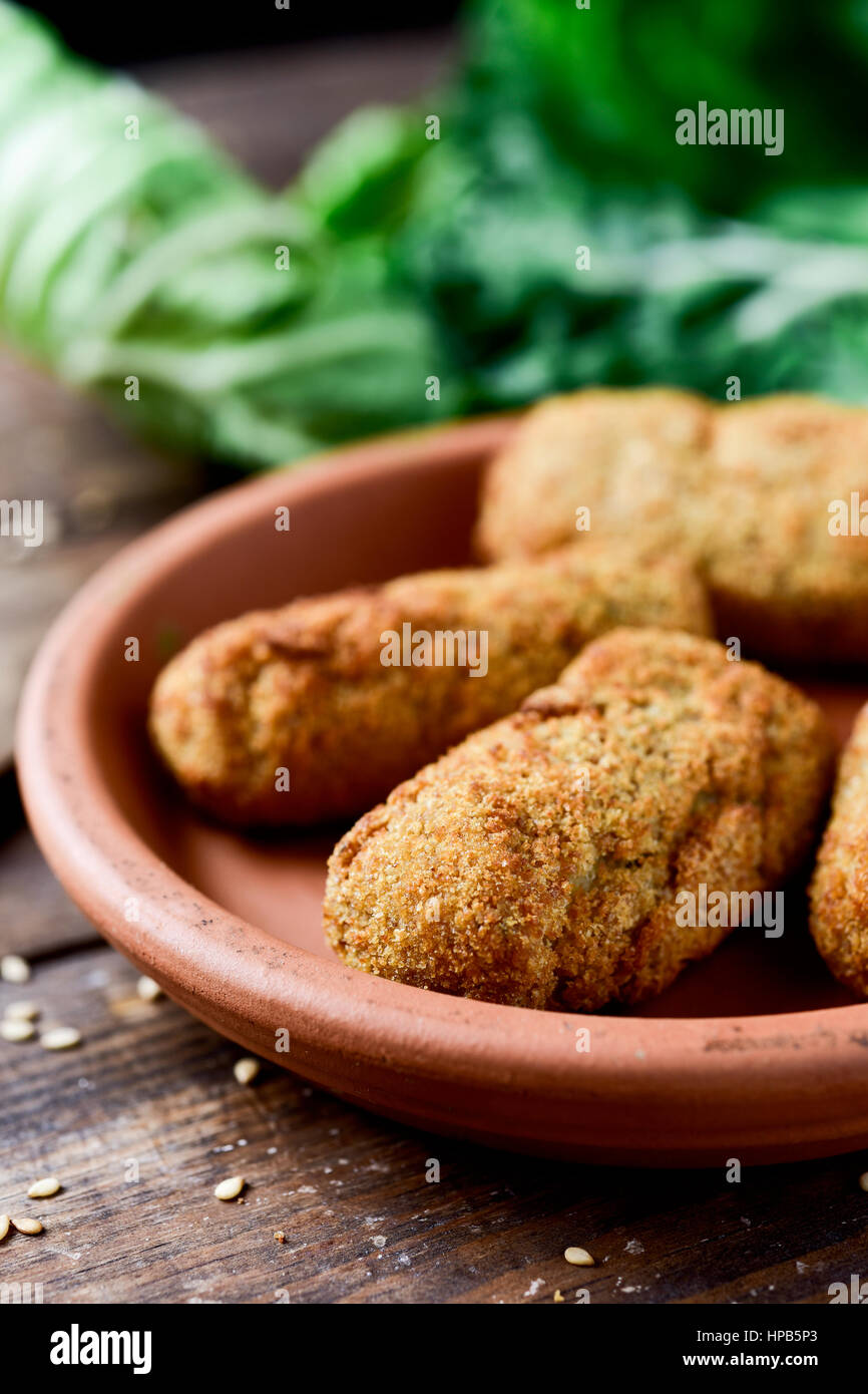Nahaufnahme eines Steingut Platte mit einige hausgemachte Croquetas, spanische Kroketten auf einem rustikalen Holztisch Stockfoto