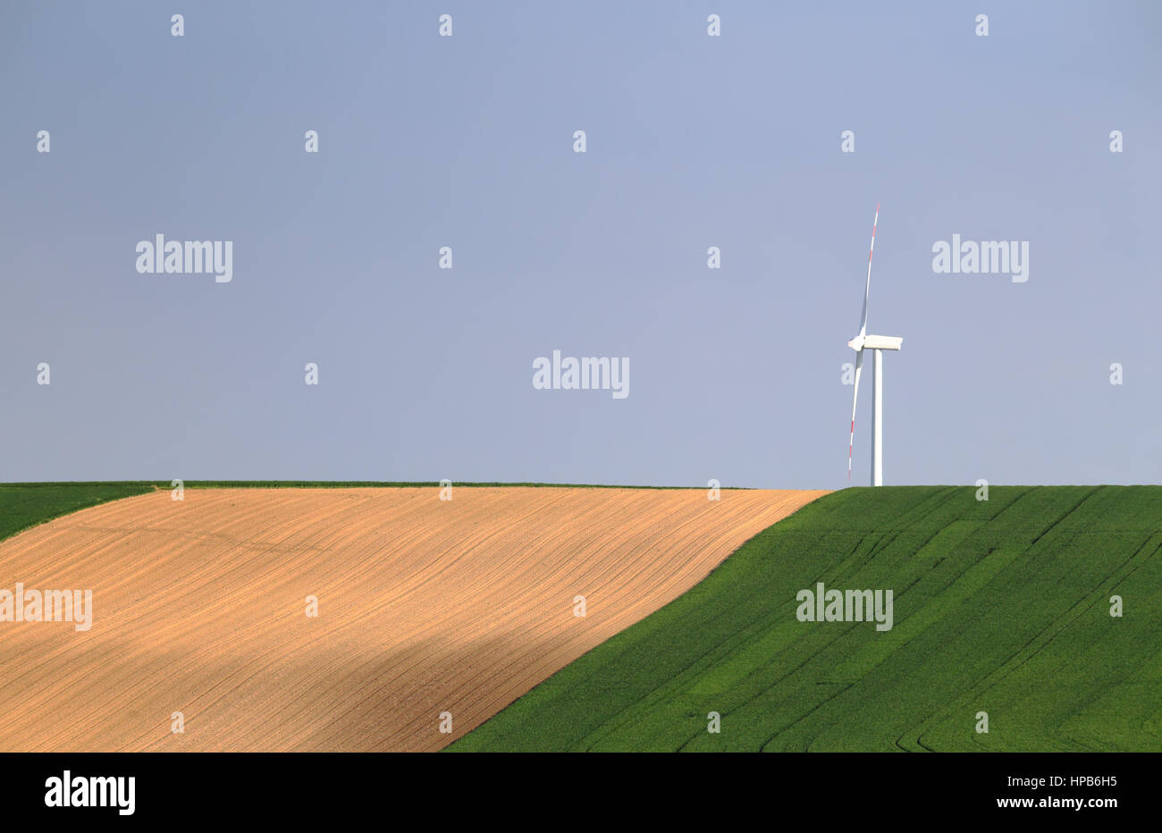 Wind Turbinel auf blauen Himmelshintergrund. Weiße Windkraftwerk im grünen Bereich. Umweltschutz-Konzept. Keine Verschmutzung-Energie im Hintergrund. Stockfoto