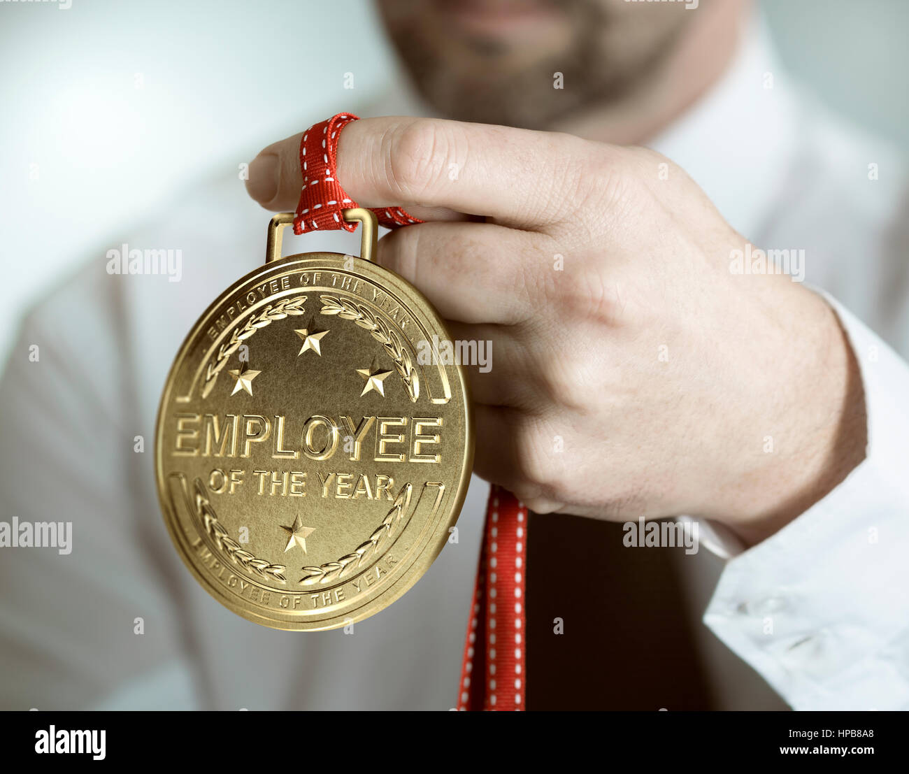 Mitarbeiter und goldene Medaille mit dem Text Mitarbeiter des Jahres. Anreiz und Motivation Konzept Stockfoto