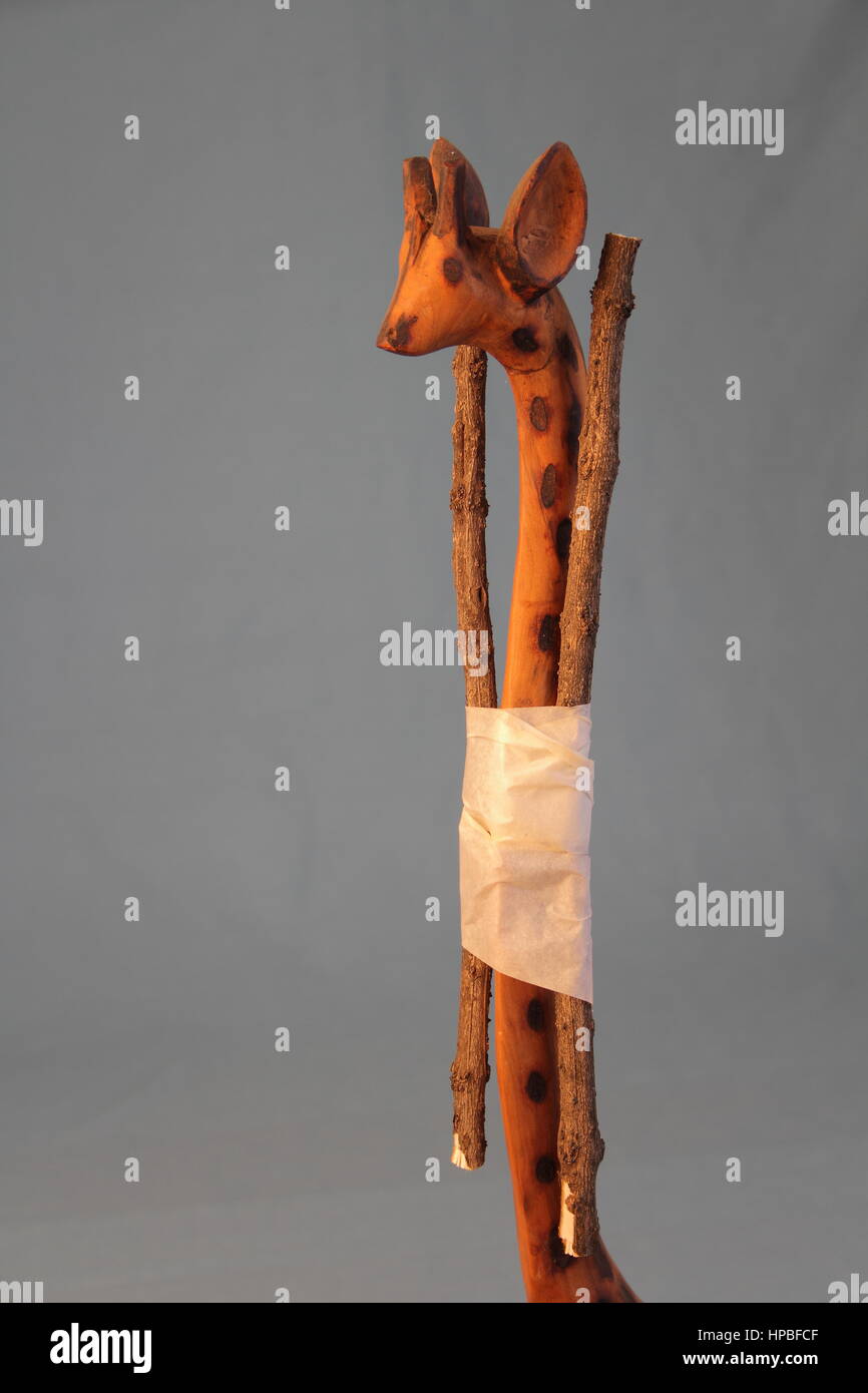 Ein Modell aus Holz Giraffe mit Schienen gemacht von rau-Sticks um den Hals in die aufrechte Position klar Hintergrund Hochformat zu unterstützen Stockfoto