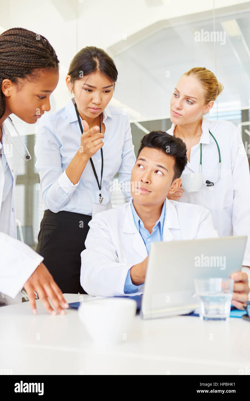 Interracial-Team von Ärzten in der Ausbildung mit Tablet-PC in der medizinischen Schule Stockfoto