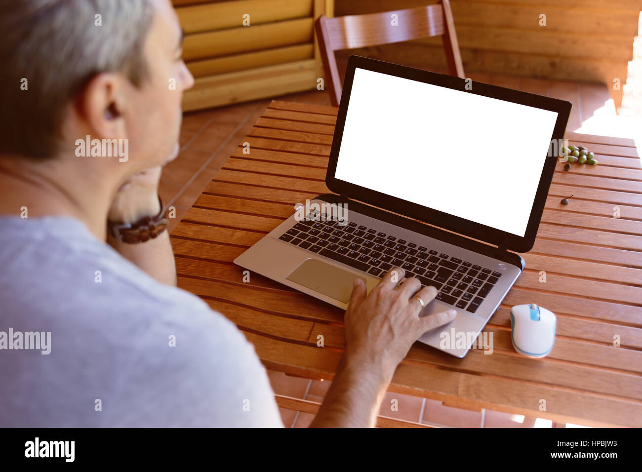 Geschäftsmann auf Laptop-Computer mit Tablet-pc auf Holztisch zu Hause arbeiten. Arbeiten zu Hause, home Office Konzept. Mann arbeitet während des Urlaubs. Mann Stockfoto
