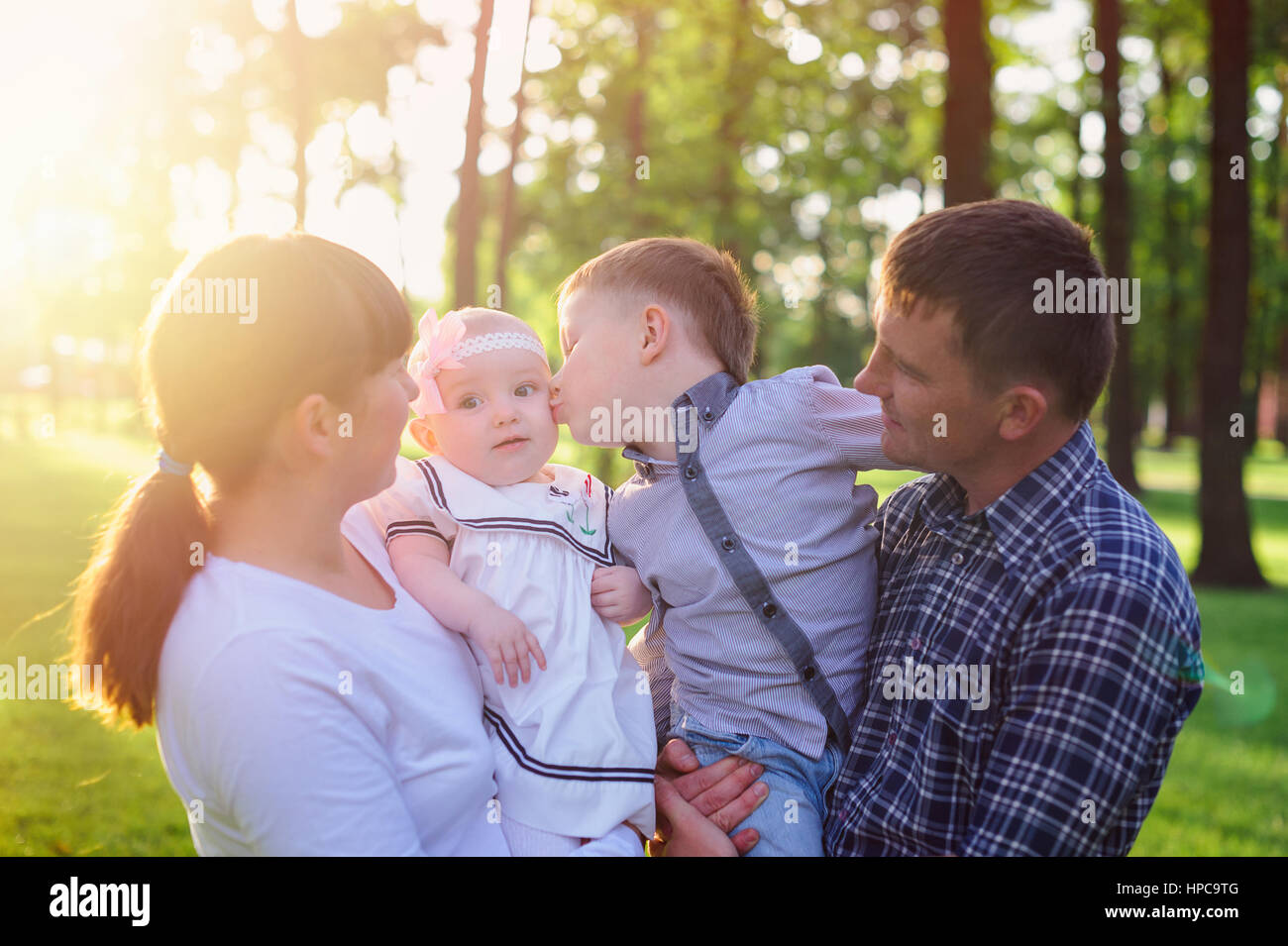 Junge Eltern mit Kindern spazieren im Sommerpark Stockfoto