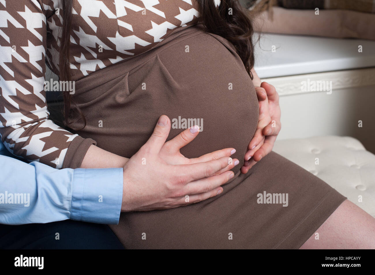 Mann umarmt seine schwangere Frau im studio Stockfoto