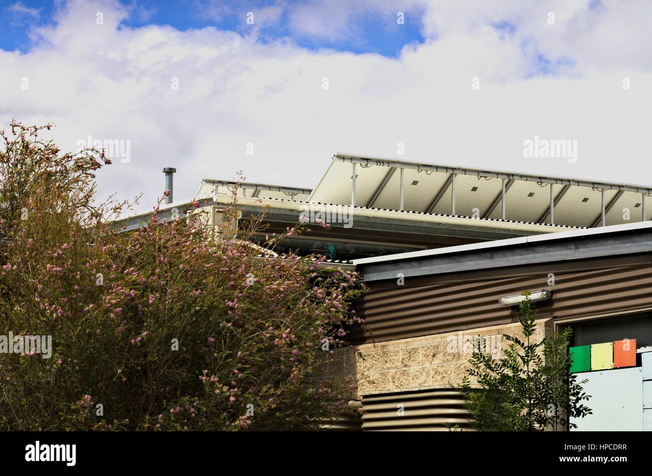 Eine Reihe von Solarzellen auf einer australischen Schule Dach angehoben, um die Sonne zu fangen. Stockfoto