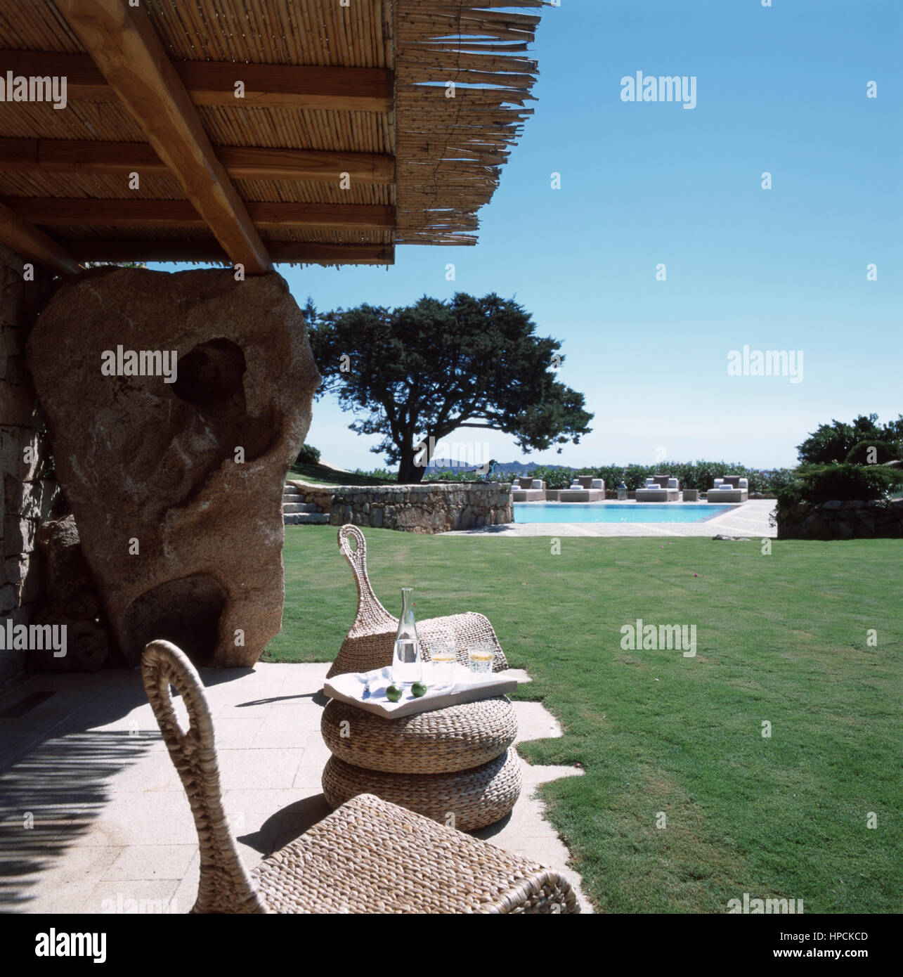 Garten Park von einem italienischen Luxus Villa in Port Cervo, Sardinien mit zwei Stühlen, einem kleinen Tisch und zwei Gläser Wasser mit Blick auf einen wunderschönen Pool Stockfoto