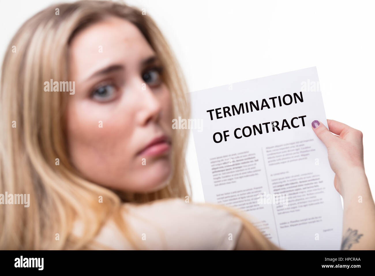 Beschäftigung-Kündigung-Konzept, Fokus auf eine Beendigung der Beschäftigung Dokument mit eine traurige besorgt blonde Frau unscharf starrt dich an Stockfoto