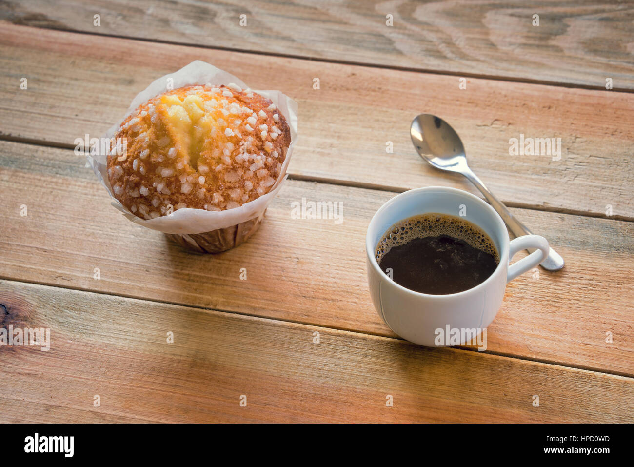 Tasse Kaffee und Muffins auf einem rustikalen Holztisch Stockfoto