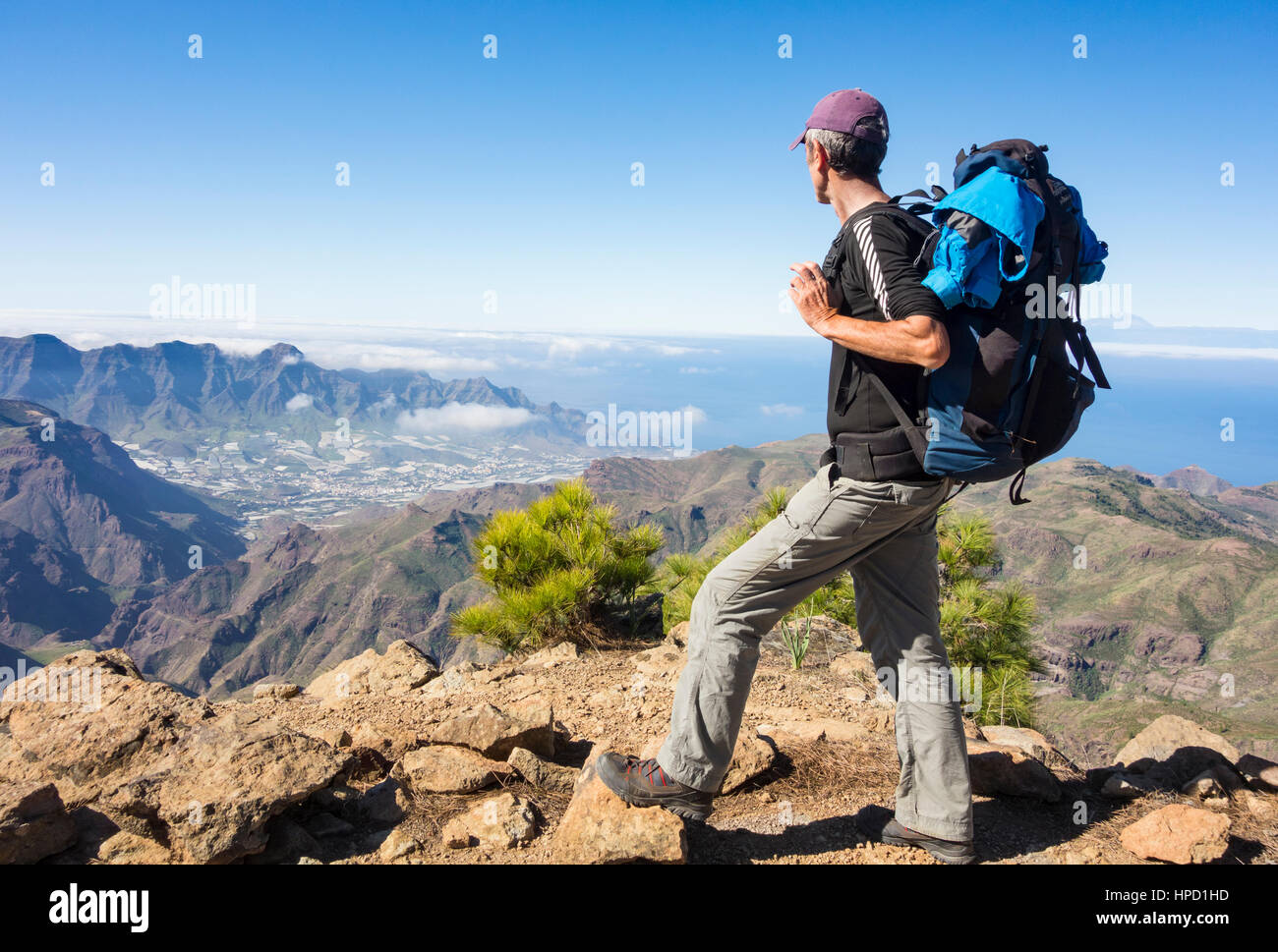 Ältere männliche Wanderer auf Alta Vista Berg auf Gran Canaria mit La Aldea de San Nicolas Dorf in Ferne. Kanarischen Inseln. Spanien Stockfoto