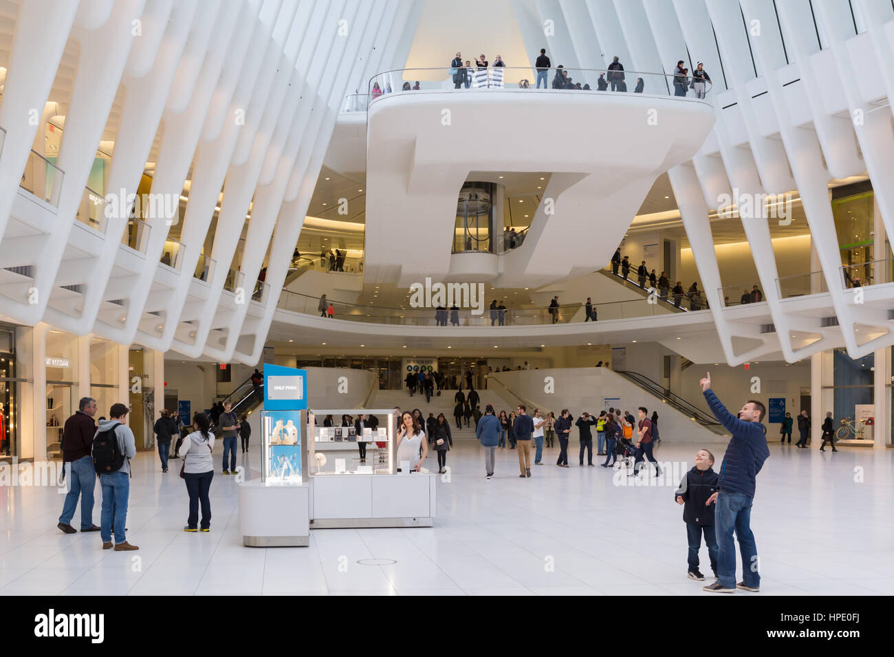 Shopping-Fans und Touristen genießen den Blick ins Innere der Oculus und Geschäfte im Einkaufszentrum Westfield World Trade Center in New York City. Stockfoto