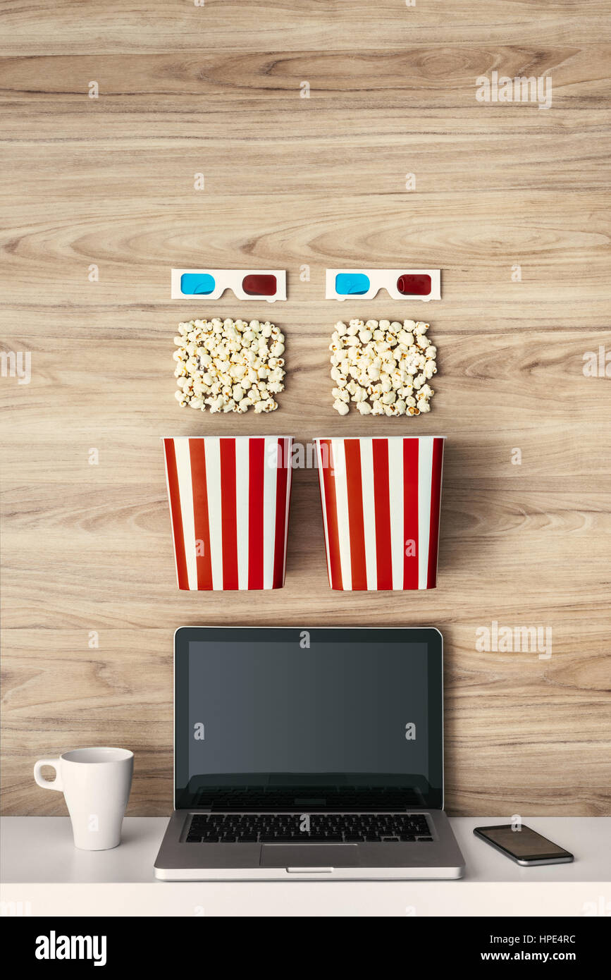 Laptop, Popcorn und 3D Brille auf einem hölzernen Oberfläche, Kino und Entertainment-Konzept Stockfoto
