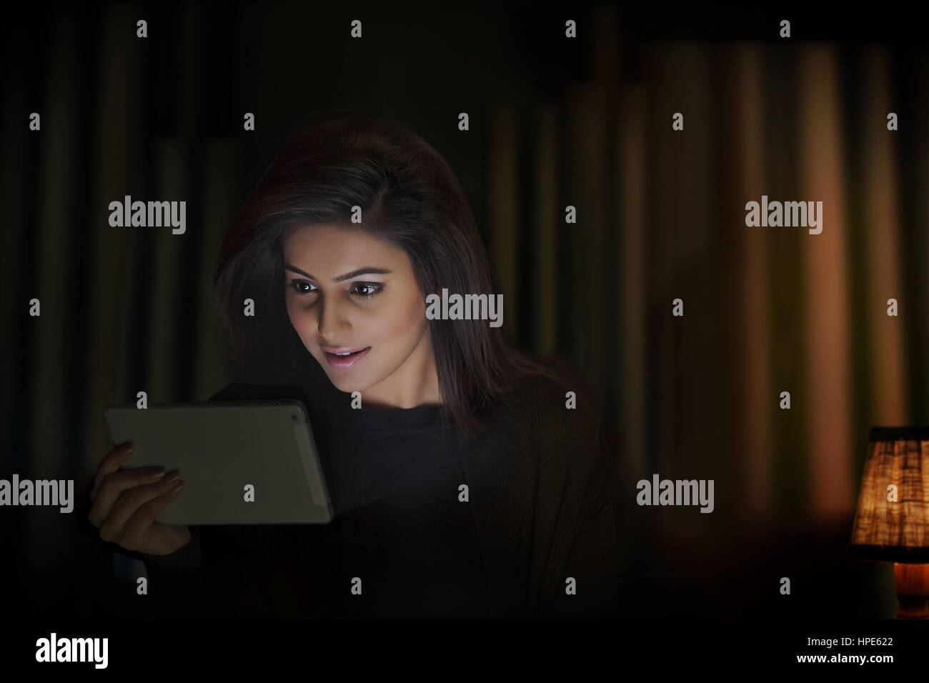 Frau mit digital-Tablette in einem dunklen Raum Stockfoto