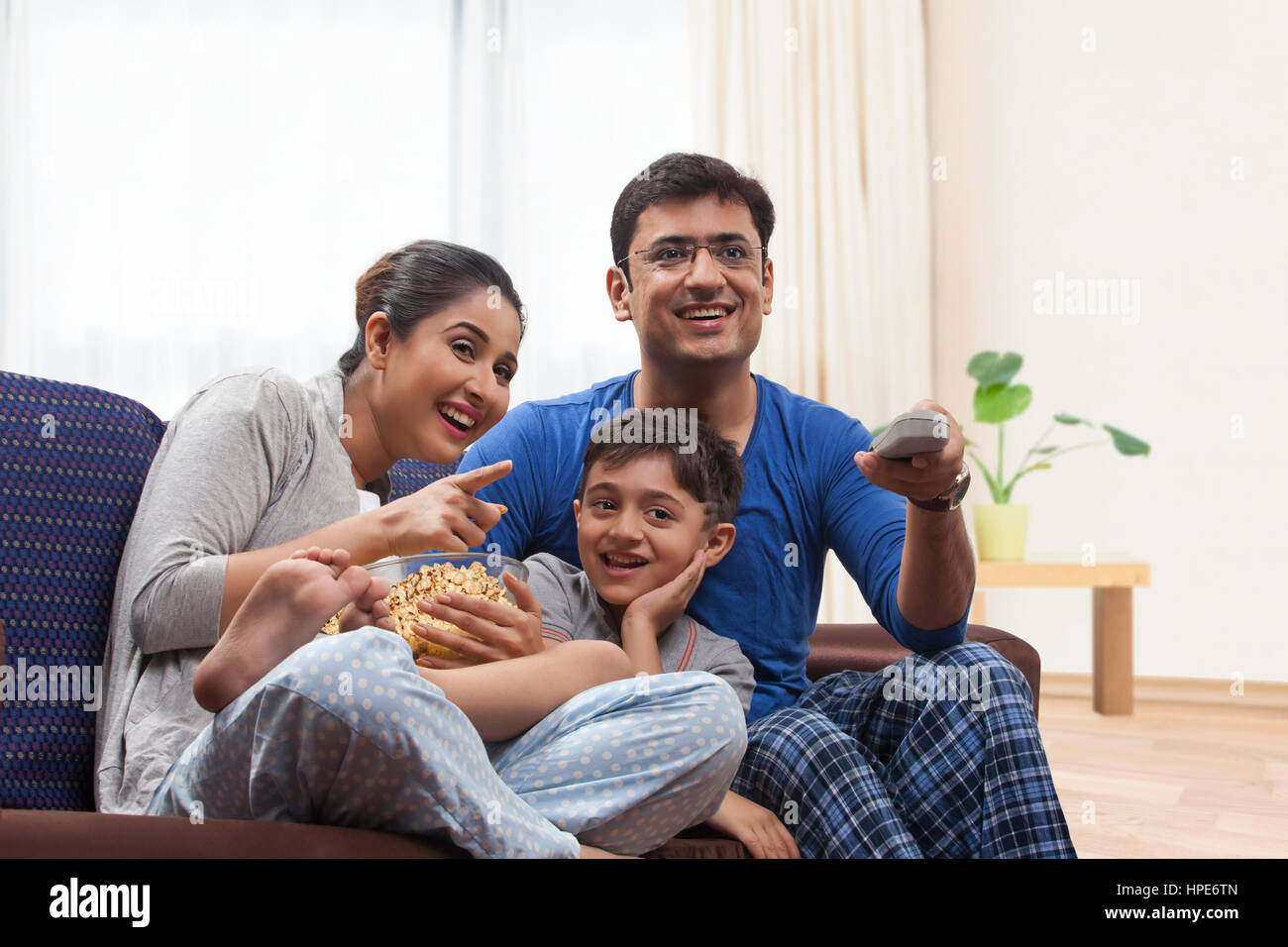 Glückliche Familie mit Popcorn während des Fernsehens Stockfoto