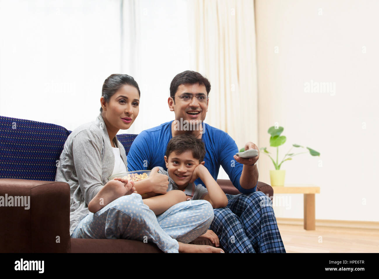 Lächelnd Familie mit Popcorn vor dem Fernseher im Wohnzimmer Stockfoto