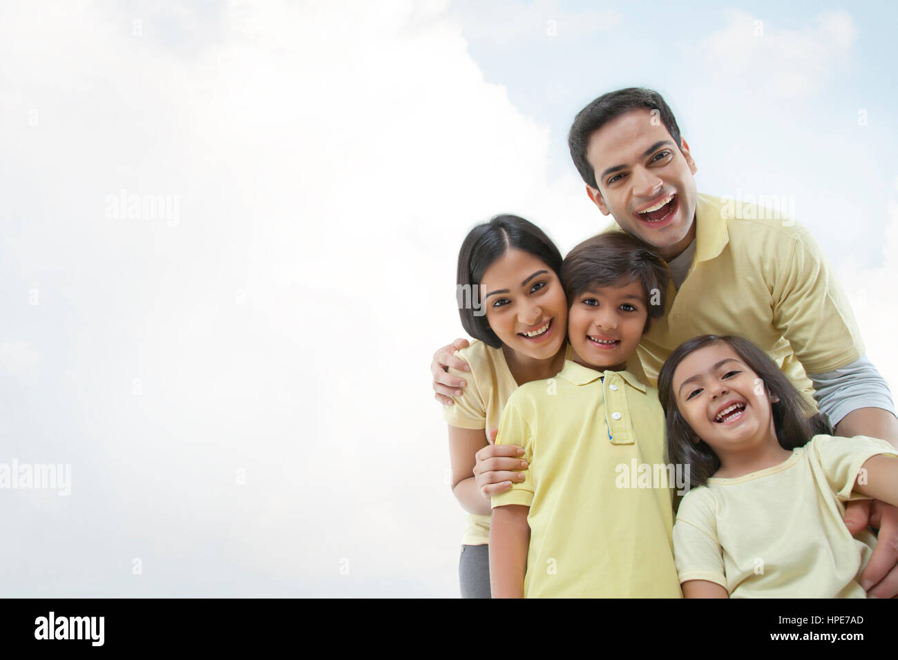 Glückliche junge Familie gegen den klaren Himmel Stockfoto