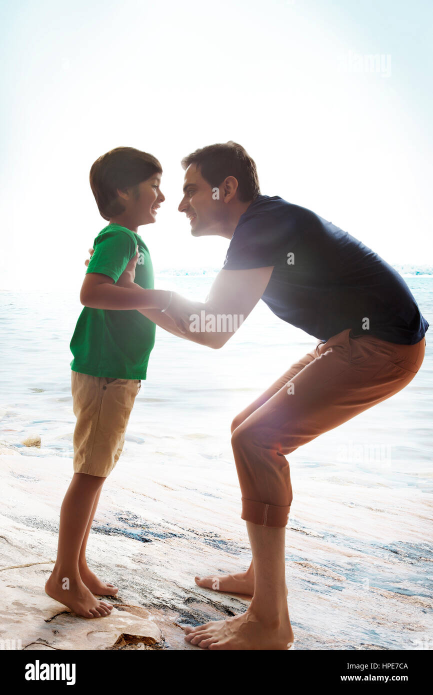 Fröhliche Vater Sohn am Strand auf sonnigen Tag heben Stockfoto